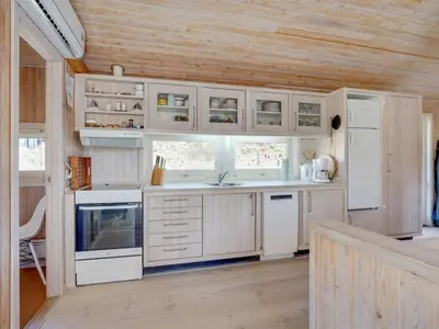 a kitchen with white appliances and a wooden ceiling at Holiday Home Nikodina - 200m from the sea by Interhome in Saltum