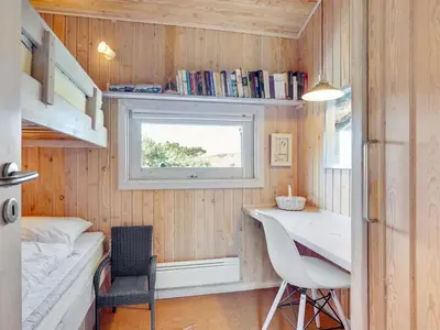 a tiny house with a desk and a window at Holiday Home Nikodina - 200m from the sea by Interhome in Saltum