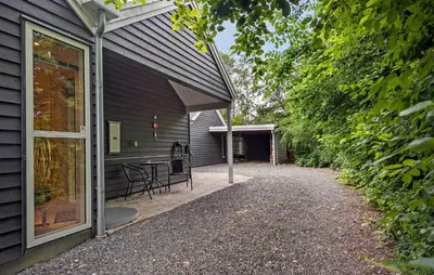 a patio with a table and chairs on the side of a house at Amazing Home In Farsø With Sauna in Farsø