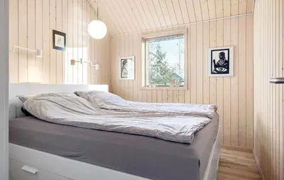 a bed sitting in a room with a window at Amazing Home In Farsø With Sauna in Farsø