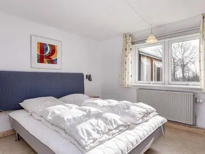 a bedroom with a bed with white sheets and a window at 2 person holiday home in Snedsted-By Traum in Snedsted