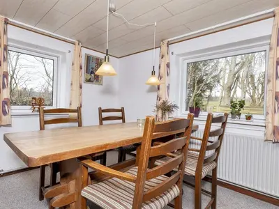 a dining room with a wooden table and chairs at 2 person holiday home in Snedsted-By Traum in Snedsted