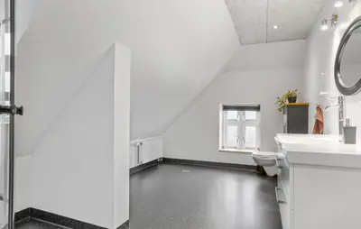 a white bathroom with a toilet and a sink at Nice Home In Roslev With Kitchen in Roslev