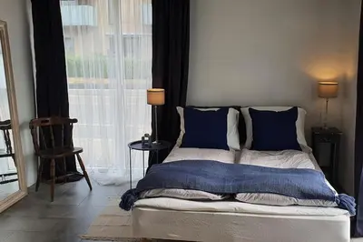 a bedroom with a bed with blue pillows and a window at Centralt by hus Blokhus-Hune til 10 pers privat Gårdhave in Blokhus