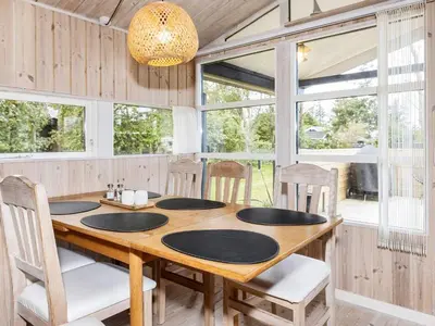 a dining room with a wooden table and chairs at Tranquil Beach Retreat - By Traum Ferienwohnungen in Løkken