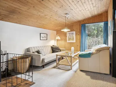 a living room with a couch and a table at Holiday Home Suri - 200m to the fjord by Interhome in Thyholm