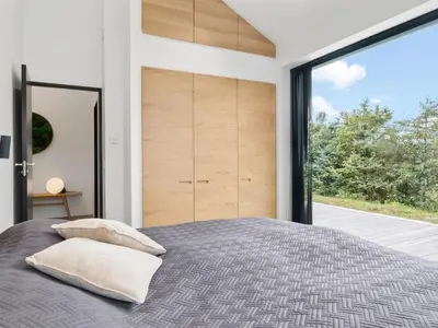 a bedroom with a bed and a large window at Holiday Home Ilja - 800m from the sea by Interhome in Blokhus