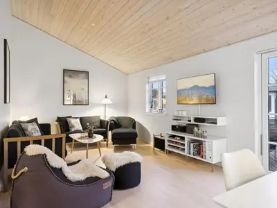 a living room with white walls and a wooden ceiling at Holiday Home Svante - 600m from the sea by Interhome in Blokhus