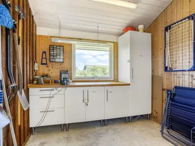 a kitchen with white cabinets and a window at Holiday Home Joris - 1-5km from the sea by Interhome in Løkken