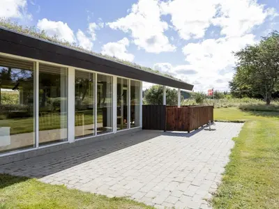 a building with large windows and a patio at Holiday Home Joris - 1-5km from the sea by Interhome in Løkken