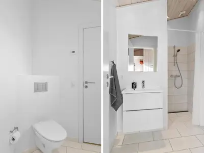 a white bathroom with a toilet and a sink at Holiday Home Mirla - 50m from the sea by Interhome in Saltum