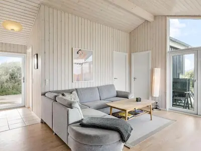 a living room with a couch and a table at Holiday Home Mirla - 50m from the sea by Interhome in Saltum