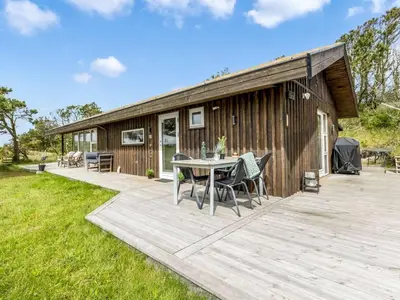a wooden deck with a table and chairs on it at Holiday Home Lagho - 500m from the sea by Interhome in Pandrup