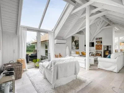 a living room with white furniture and a large window at Holiday Home Verner - 900m from the sea by Interhome in Fjerritslev