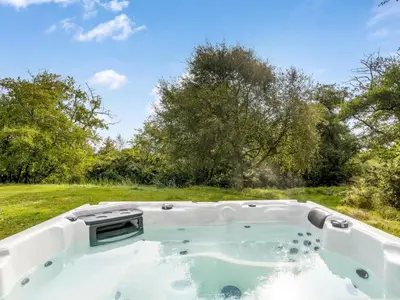 a jacuzzi tub in a field with trees at Holiday Home Verner - 900m from the sea by Interhome in Fjerritslev