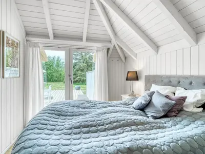 a bedroom with a large bed with a large window at Holiday Home Verner - 900m from the sea by Interhome in Fjerritslev