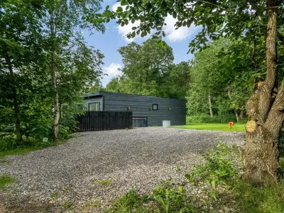a house in the woods with a gravel driveway at Holiday Home Scalli - 1-5km to the fjord by Interhome in Farsø