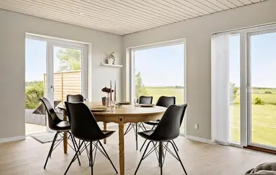 a dining room with a wooden table and black chairs at Nice Home In Thyholm With Wifi in Thyholm