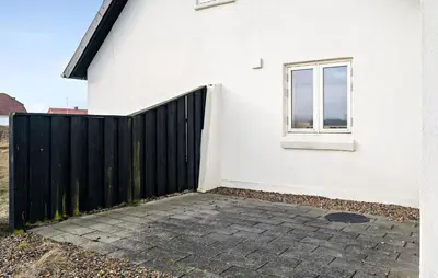 a white house with a black fence and a window at Amazing Home In Harboøre With Kitchen in Harboør