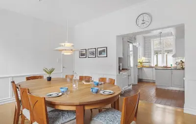 a kitchen and dining room with a wooden table and chairs at Gorgeous Home In Løgstør in Løgstør