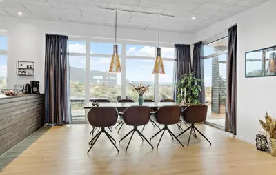 a dining room with a table and chairs and large windows at Gorgeous Home In Thisted With Wifi in Thisted