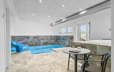 a room with a table and a tub and a pool at Stunning Home In Løgstrup With Kitchen in Løgstrup