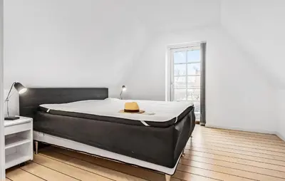 a bedroom with a bed with a hat on it at Amazing Home In Blokhus With Kitchen in Blokhus
