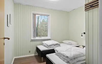 two beds in a room with a window at 3 Bedroom Pet Friendly Home In Højslev in Højslev