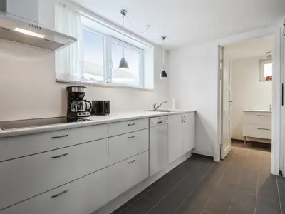 a white kitchen with white cabinets and a window at Holiday Home Mirja - 50m to the fjord by Interhome in Fur