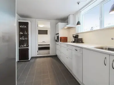 a white kitchen with white cabinets and a window at Holiday Home Mirja - 50m to the fjord by Interhome in Fur