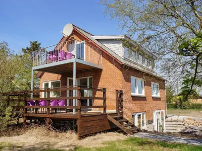 a brick house with a balcony and a deck at Holiday Home Mirja - 50m to the fjord by Interhome in Fur