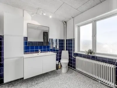 a bathroom with a sink and a toilet and a window at Holiday Home Ullakarin - 200m from the sea by Interhome in Thyborøn