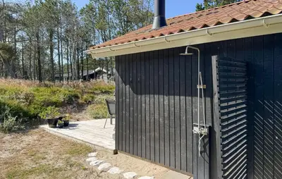 a black building with a wooden deck with a shower at 3 Bedroom Cozy Home In Thisted in Thisted