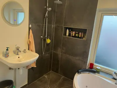 a bathroom with a sink and a toilet and a shower at Nice small house 5 minutes to the sea in Ranum