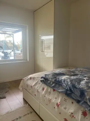 a bedroom with a bed next to a window at Nice small house 5 minutes to the sea in Ranum