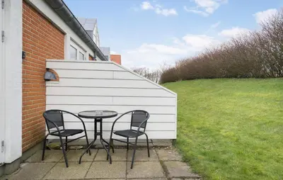 a table and chairs on a patio next to a building at 2 Bedroom Nice Apartment In Lemvig in Lemvig