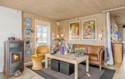 a living room with a table and a fireplace at 4 Bedroom Beautiful Home In Pandrup in Pandrup