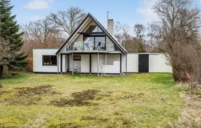a white house with a gambrel roof at Amazing Home In Roslev With Sauna in Roslev
