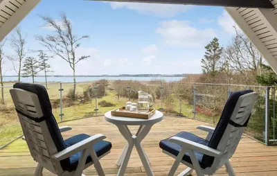 two chairs and a table on a deck with a view at Amazing Home In Roslev With Sauna in Roslev