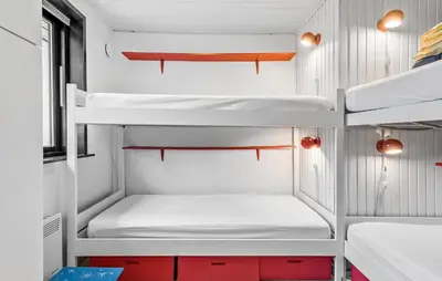 a room with white bunk beds and red cabinets at Amazing Home In Roslev With Sauna in Roslev