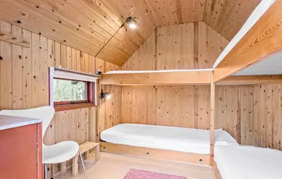 a bedroom with a bunk bed in a wooden cabin at Amazing Home In Roslev With Sauna in Roslev