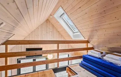 an attic room with a wooden ceiling and a window at Amazing Home In Roslev With Sauna in Roslev