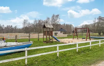 a park with a playground with a wooden fence at Amazing Home In Roslev With Sauna in Roslev