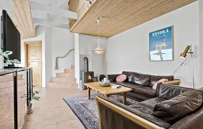 a living room with a couch and a table at Cozy Home In Frøstrup With Sauna in Frøstrup