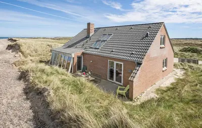 a small brick house on the side of a beach at Cozy Home In Frøstrup With Sauna in Frøstrup