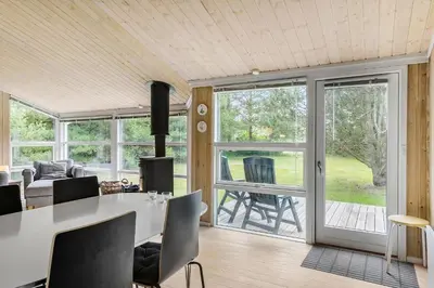 a living room with a table and chairs and sliding glass doors at Little Fiskerbanke - Lovely, Private, And Family-Friendly Holiday Home in Saltum