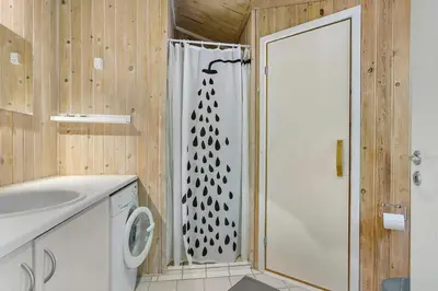 a bathroom with a shower with a shower curtain at Little Fiskerbanke - Lovely, Private, And Family-Friendly Holiday Home in Saltum