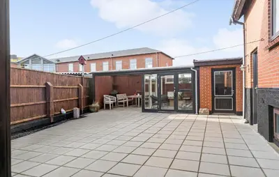 an outdoor patio with glass doors and a table at 1 Bedroom Nice Apartment In Thyborøn in Thyborøn