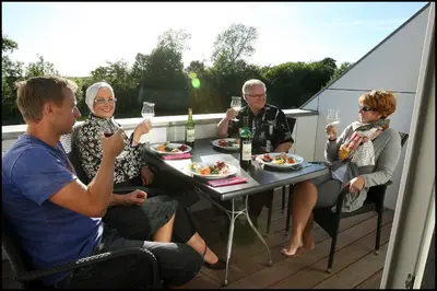 a group of people sitting around a table with wine glasses at Volstrup Ferieboliger in Stenild