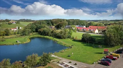 an aerial view of a town with a lake at Volstrup Ferieboliger in Stenild